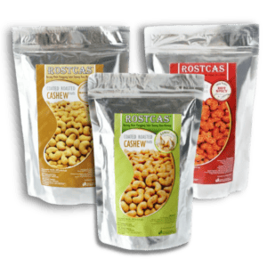 Three silver pouches of halal-certified roasted cashews by Rostcas, featuring original and spicy gourmet flavors. | Emping SG