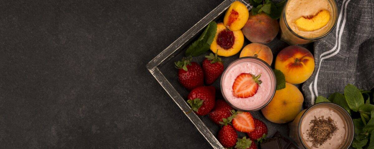 Three glasses of smoothies—strawberry, peach, and chocolate—make a smart nutrition midnight snack on a dark background. | Emping SG