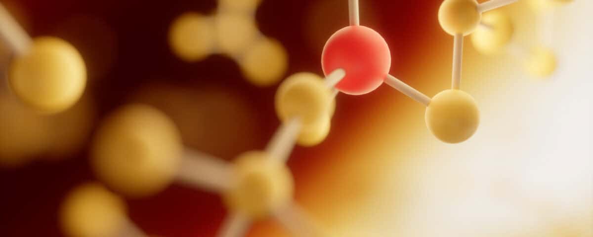 A close-up illustration of purine compounds with yellow and red spheres connected by rods on a warm, blurred background. | Emping SG
