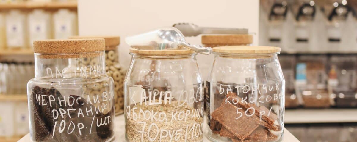 Three glass jars with wooden lids offer convenient food storage, labelled in Russian and set on a white counter. | Emping SG