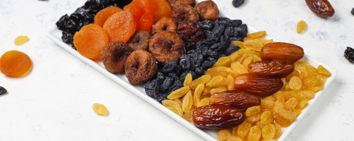 A rectangular plate with dried fruit snacks like apricots, figs, and dates arranged for everyday wellbeing. | Emping SG