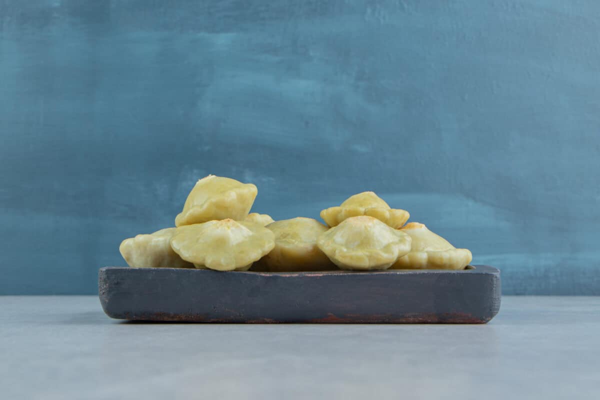 A row of melinjo fruit pieces on a tray with Emping Belinjo, reflecting Indonesian tradition against a blue background. | Emping SG