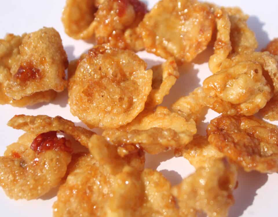 Close-up of cornflake biscuits and Premium Quality Melinjo Crisps, both glazed with honey and showing a crispy, golden-brown texture. | Emping SG