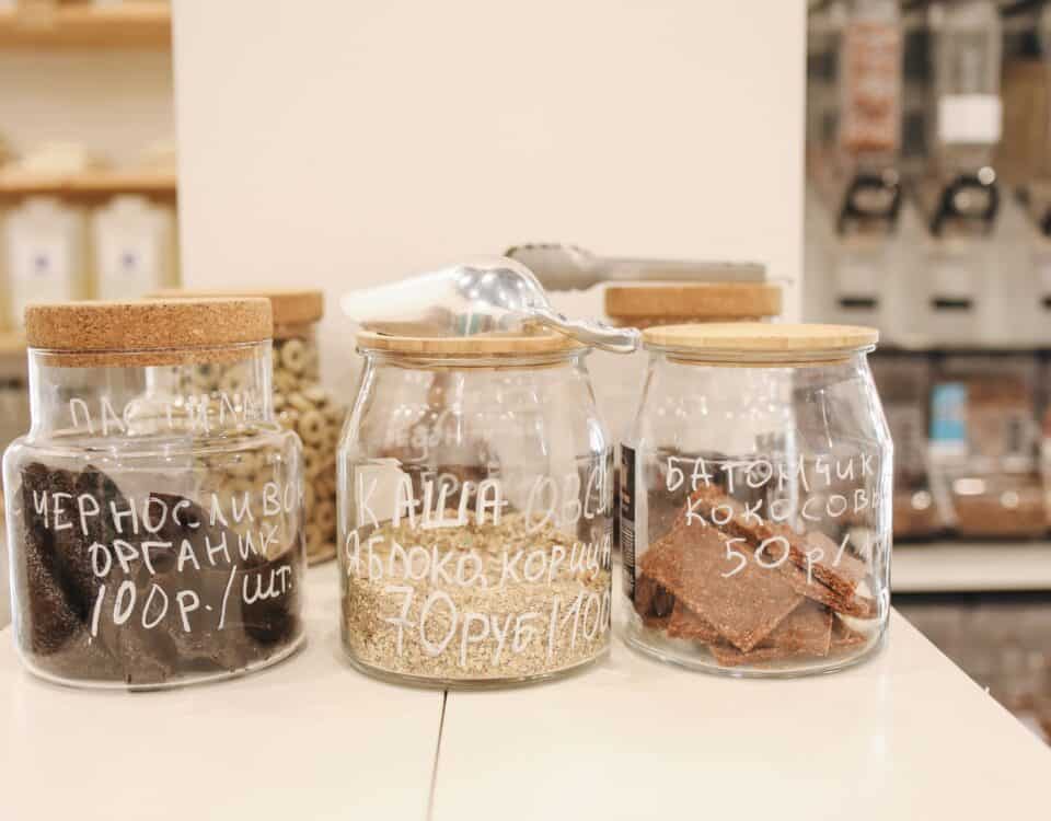 Three glass jars with wooden lids offer convenient food storage, labelled in Russian and set on a white counter. | Emping SG