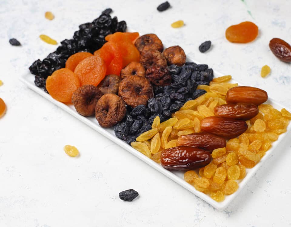 A rectangular plate with dried fruit snacks like apricots, figs, and dates arranged for everyday wellbeing. | Emping SG